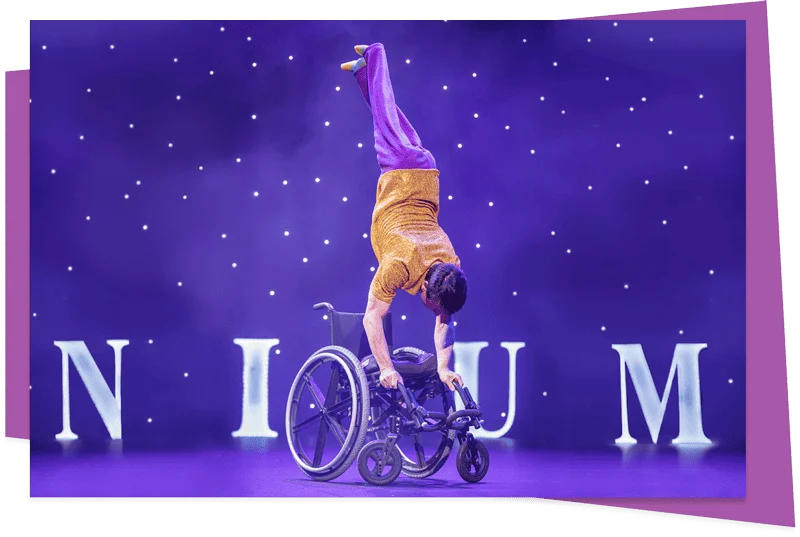 Omnium Circus performer Rik Daniels doing a handstand on his wheelchair during I'm Possible II